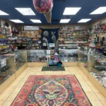 Interior of Canutillo Smoke Shop showing Lunar Lounge space theme with alien rug, cosmic tapestry, and glass display cases