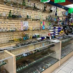 Close-up view of the glass wall at Fox Plaza Smoke Shop, showcasing bongs, pipes, and one-hitters.