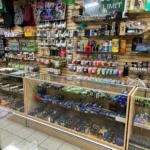 Posters, rolling trays, scales, and vape juice displayed at Fox Plaza Smoke Shop in El Paso.