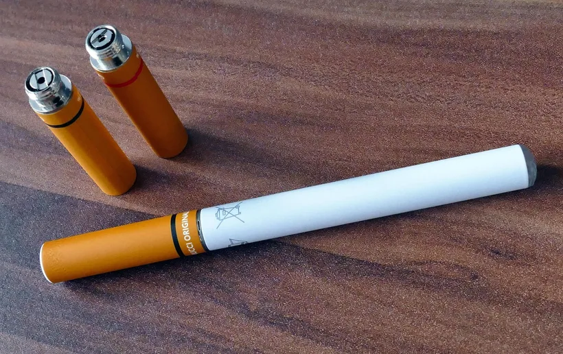 Disposable e-cigarette devices laid out on a wood surface showing the compact single-use format at El Paso Smoke Shops