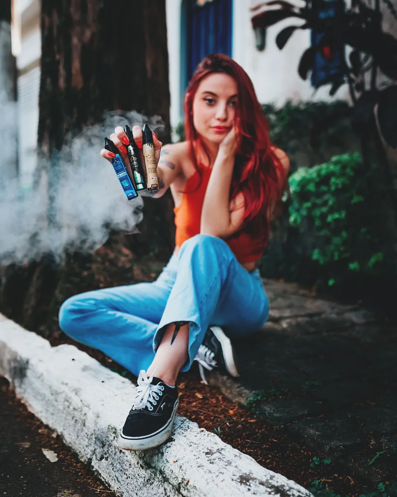 Una mano abriendo en abanico cuatro vapes desechables distintos con un hilito de vapor en El Paso Smoke Shops