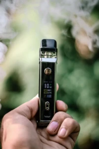 Close-up of a vape device held in hand with its screen displaying a live puff counter reading PUFF 0021, illustrating how puff counts are tracked at El Paso Smoke Shops
