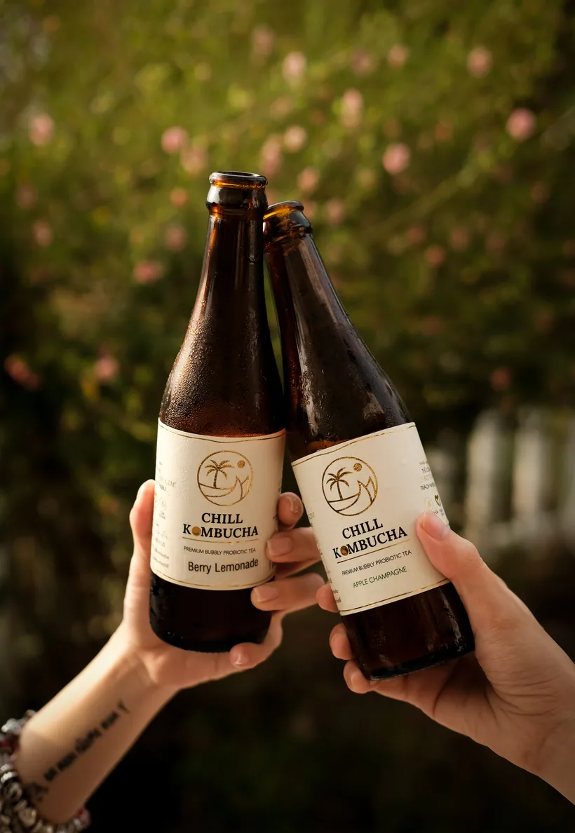 Two people toasting bottles labeled premium bubbly probiotic kombucha tea at El Paso Smoke Shops
