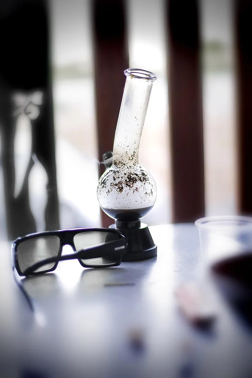 A clear glass water pipe showing stuck-on resin buildup along the inside walls and bowl at El Paso Smoke Shops