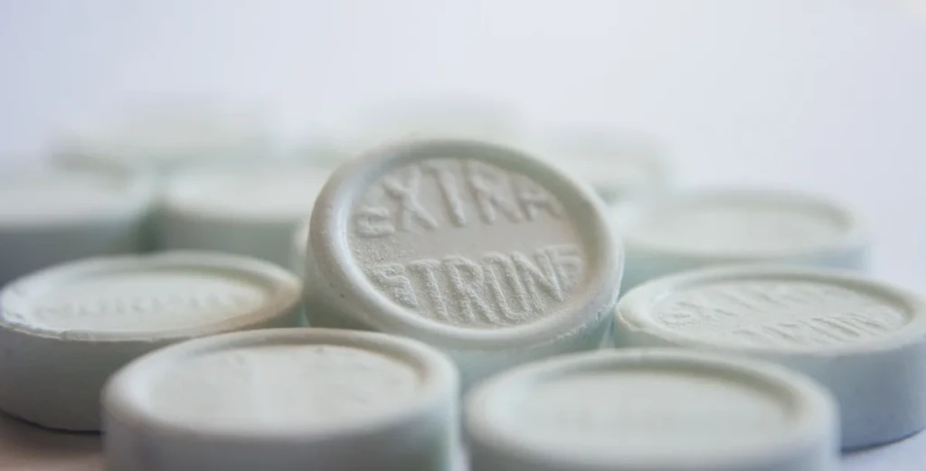 Close-up of round, pressed white dissolvable lozenge tablets stacked together, the same format as Nic Nac nicotine lozenges at El Paso Smoke Shops
