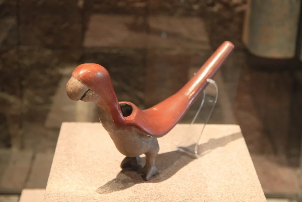 Clay smoking pipe sculpted into the shape of a colorful macaw bird, an animal-shaped novelty hand pipe at El Paso Smoke Shops