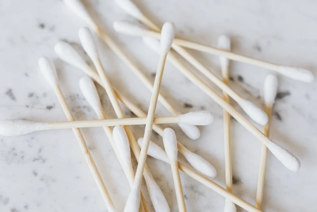A scattered pile of bamboo-stick cotton swabs on a marble surface, the hand tool for cleaning pipe stems and bangers at El Paso Smoke Shops