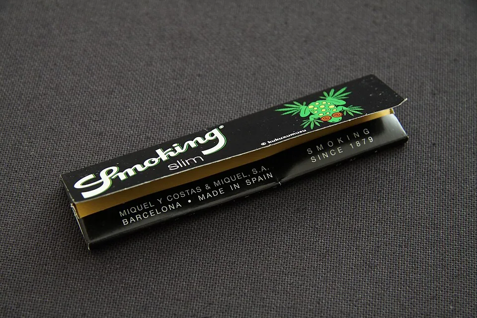 A slim-size rolling papers booklet resting on a dark textured surface, ready to be used with pre-rolled cones at El Paso Smoke Shops