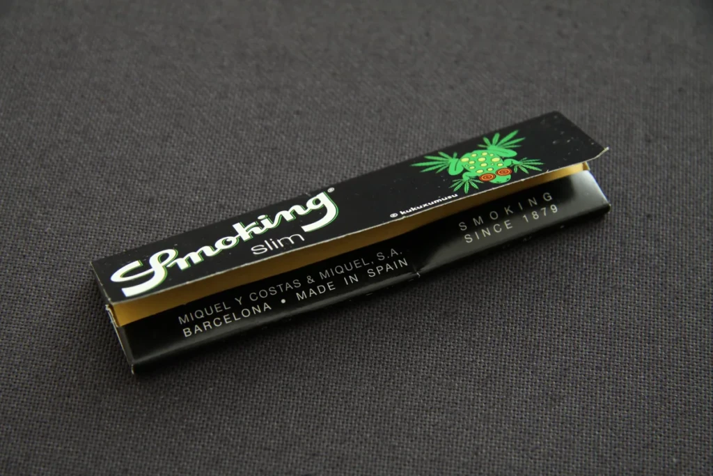 A slim booklet of Smoking brand cigarette rolling papers on a dark studio backdrop at El Paso Smoke Shops