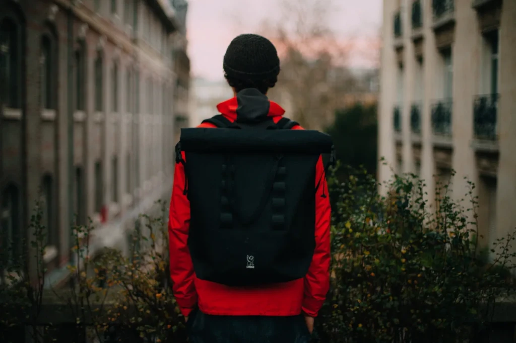 A person wearing a sleek black backpack on a city street, the kind of low-profile carry-bag featured at El Paso Smoke Shops