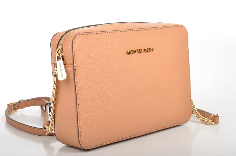 Tan leather crossbody sling bag showing its top zipper closure and adjustable chain strap at El Paso Smoke Shops