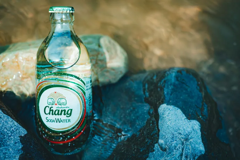 Glass bottle labeled Soda Water resting on wet river rocks at El Paso Smoke Shops