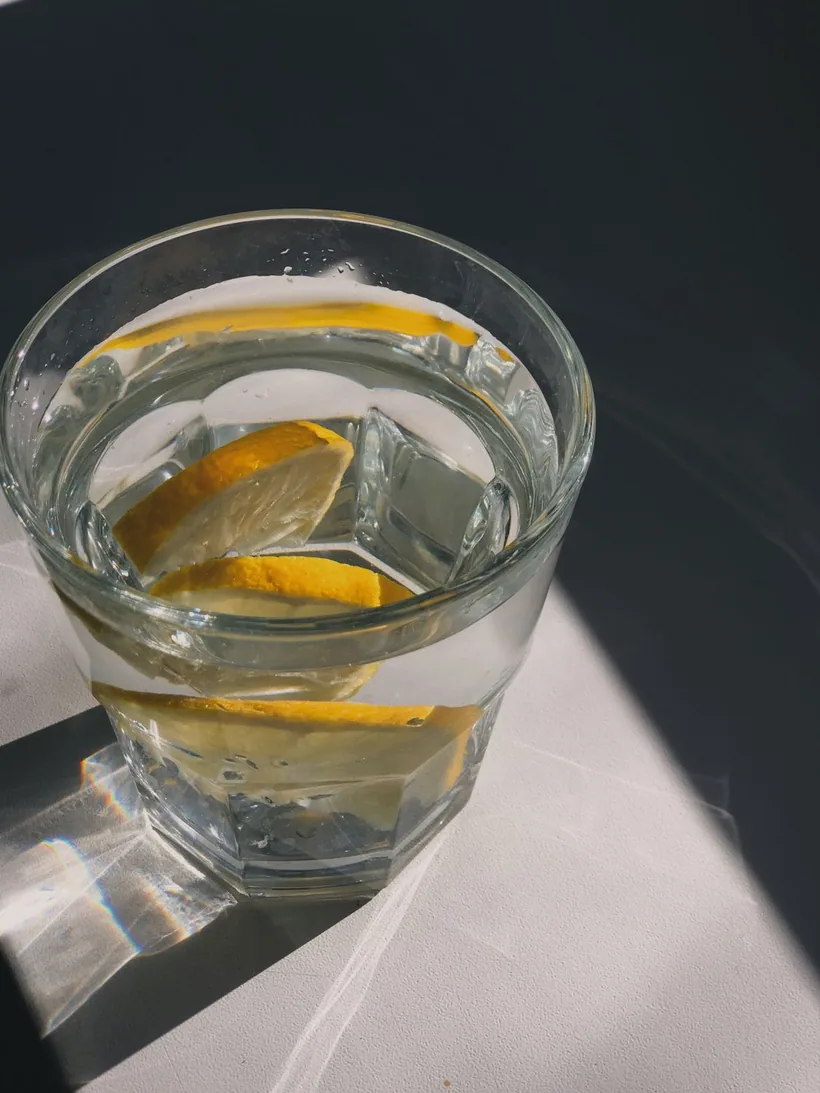 Glass of water with fresh lemon wedges lit by hard sunlight at El Paso Smoke Shops