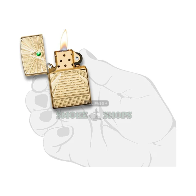 Zippo Eye of Providence windproof lighter in High Polish Brass with a deep-carved pyramid and green crystal all-seeing eye, lid closed