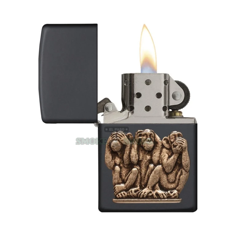 Close-up of the three-dimensional solid-brass three monkeys emblem on the black matte Zippo 29409 case